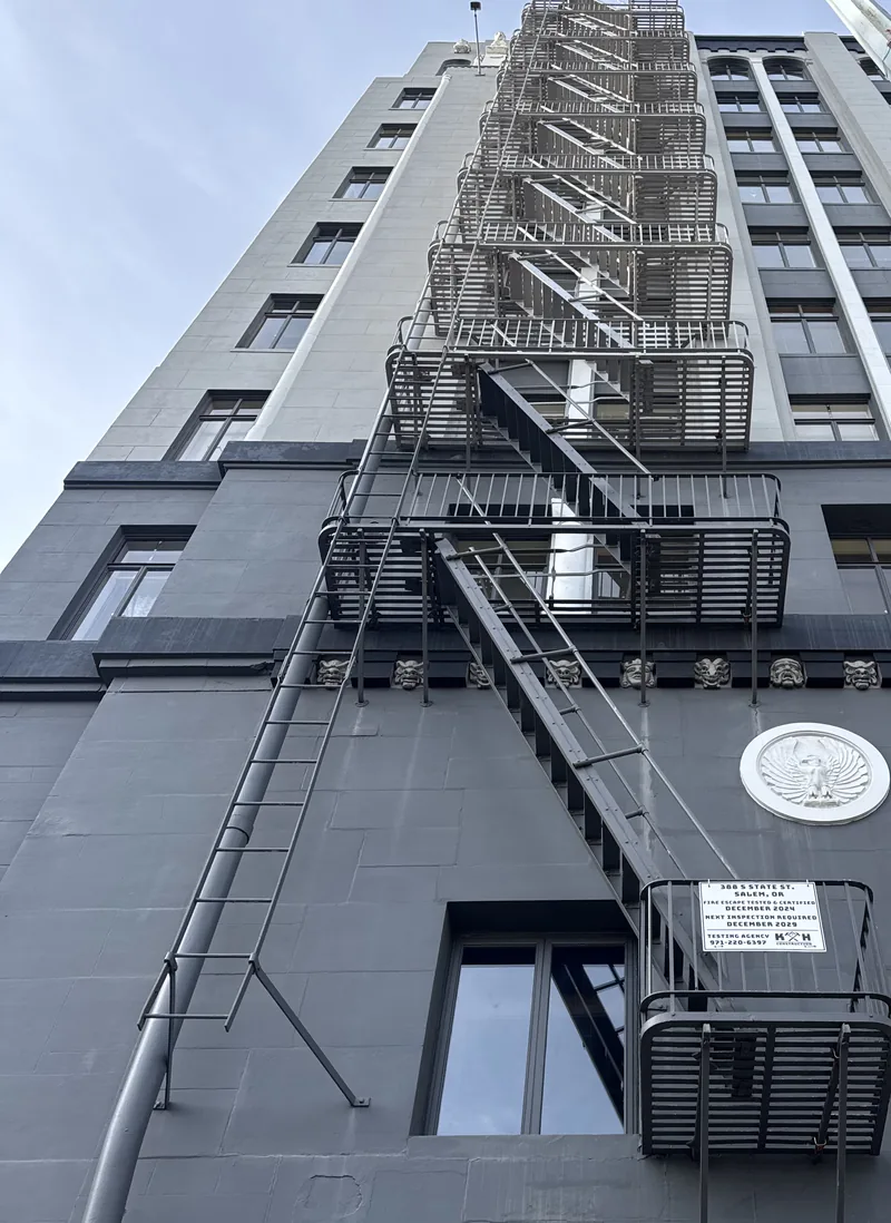 Recertified fire escape with posted K and H certification placard on an Oregon high-rise