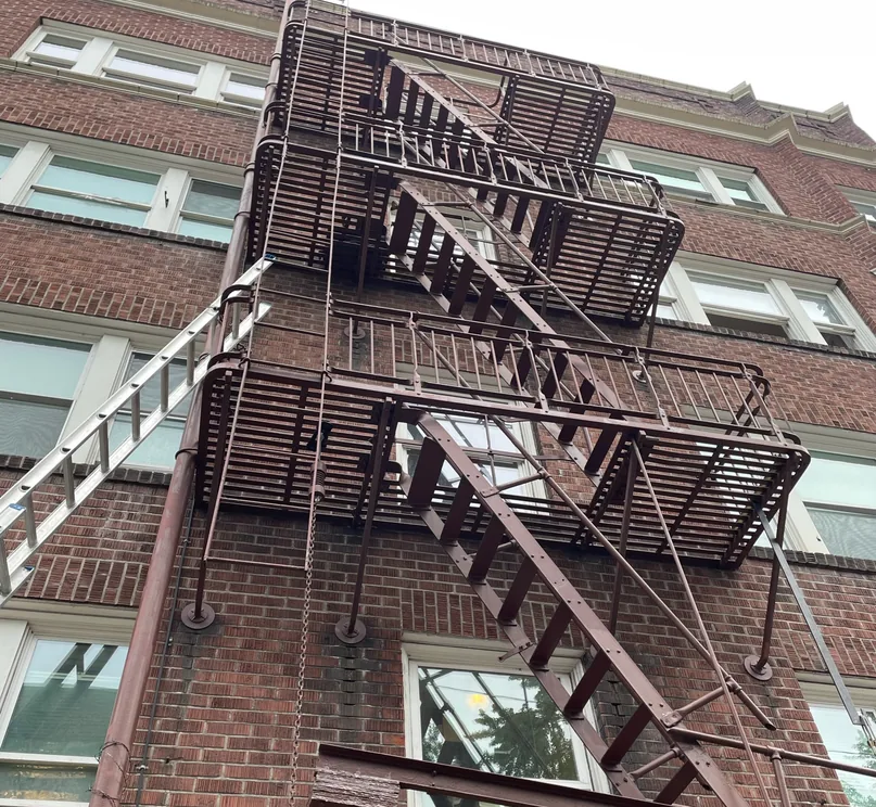 Ladder access set up for a fire escape inspection at a Portland apartment building