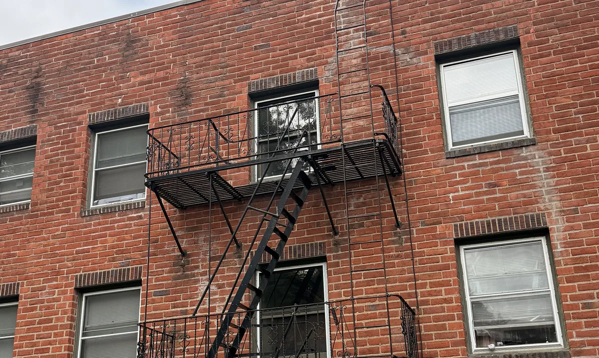 Freshly painted black iron fire escape on a red brick apartment building in Portland