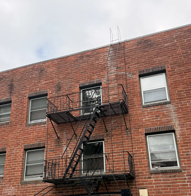 Completed fire escape repair and painting on a Portland brick apartment building