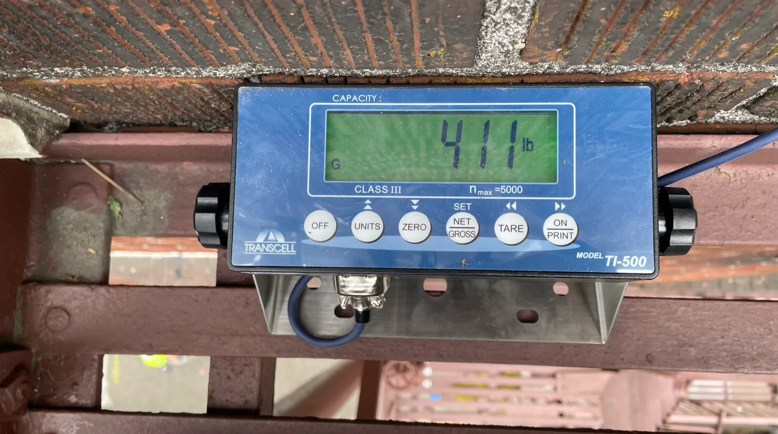 Calibrated load cell reading 411 lb during a certified fire escape load test in Portland, Oregon